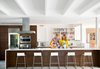 Modern home with Kitchen, Wood Cabinet, Refrigerator, Range Hood, Range, Wall Oven, Recessed Lighting, Concrete Floor, Marble Backsplashe, Marble Counter, and Undermount Sink. Their creative confections may ruin our diets, but we’re happy to be their taste testers anytime. Photo of Tips for a Pain-Free Kitchen Renovation