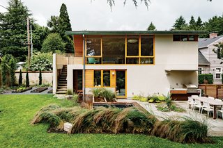 Fusion Landscape Design worked with PATH to remake the backyard into a grown-up playground. Under the stairwell sits a tiny custom cedar sauna and an outdoor shower—just a literal hop, skip, and jump away from the sprawling in-ground eight-by-ten-foot hot tub. Down three short stairs, Gloster’s Elan dining table from Design Within Reach is surrounded by Spark chairs by Don Chadwick for Knoll and a built-in fire pit and DCS grill by Fisher & Paykel—all resting on a smooth surface of bluestone pavers.