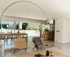 Modern home with Dining Room, Chair, Table, Floor Lighting, and Concrete Floor. A 14-foot-wide opening at the rear of the house contributes, along with the concrete flooring, to an almost seamless transition from indoors to the patio. A spate of mid-century furnishings includes chairs by Hans Wegner and Poul Kjærholm and an Achille Castiglioni Arco lamp. Photo of 17 Modern Homes With Hans Wegner Furniture
