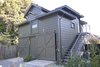 After a coat of 'ruskin bronze' Kelly Moore paint and the addition of a copper downspout, the house was completely transformed. If you look closely, the outline of the former horse-and-carriage plaque remains on the hayloft door. Photo by Susanne Friedrich. Photo of Modern East Bay Getaways modern home