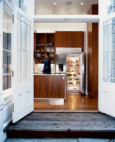 The walnut cabinets in the kitchen, which update and warm the space, were designed by Nilus de Matran and fabricated by George Slack.