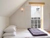 The second floor of the schoolhouse was likely used as another classroom space, one for boys and one for girls. Now, it contains two bedrooms, a smaller bunk room and a master bedroom. Photo of Schoolhouse Salvaged as a Cozy Cabin modern home