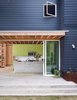 Modern home with Kitchen, Colorful Cabinet, and Concrete Counter. A tight construction budget informed the choices Sean Guess made as he designed a house for a couple in Austin, Texas. Budget-minded materials, like the James Hardie fiber-cement siding, helped hold construction costs to $130 per square foot. Sherwin-Williams’s Cyberspace hue colors the exterior and Parakeet coats the custom kitchen cabinets by Austin Wood Works. The planter is made from Cor-Ten steel. Photo of Architects Get Crafty With Budgets to Build Cost-Effective Modern Homes