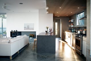 The cabinets above are from Ikea, the range is by GE, and the Jenn-Air refrigerator is tucked unobtrusively into the pantry wall. The troweled concrete floor was poured in place by builder Peter Knudsen.
