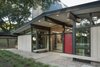 Modern home with Exterior and Mid-Century Building Type. The house’s Japanese inspiration manifests in many ways, including beams that extend outwards over the front door. Floor-to-ceiling windows around the entrance and continuous indoor-outdoor epoxy-pebble flooring blur the barrier between the interior and exterior. Photo of Renovated Midcentury Home in Austin Doubles Square Footage