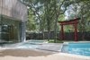 Modern home with Outdoor, Swimming Pools, Tubs, Shower, Trees, Wood Fences, Wall, Grass, and Walkways. The pool’s pinched center and a nearby shade tree reflect the Japanese concept of “wabi-sabi,” or imperfection in beauty. A large stepping stone also references a stepping stone in a Japanese garden pool. Photo of Renovated Midcentury Home in Austin Doubles Square Footage