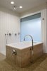 Modern home with Bath Room and Freestanding Tub. The master bath features a freestanding bathtub and elegantly curved spout. Photo of Renovated Midcentury Home in Austin Doubles Square Footage