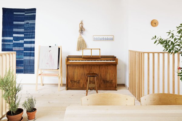 An antique Japanese indigo tapestry hangs by a vintage Danish piano.
