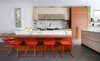 The kitchen features many built-in and hidden features. A Miele integrated refrigerator and freezer are sheathed with custom wood panels and Sub-Zero under-counter refrigerator drawers offer extra space for chilling food. Since the family cooks a lot, Fisher worked with them to incorporate specialty appliances including a Wolf Duel Fuel range, a Wolf deep fryer set into the countertop, a Miele wok burner and dishwasher, and a Panasonic microwave. A custom hood by Best keeps the space ventilated. Calcutta Gold marble adds a striking contrast to the Modulnova cabinetry and island units are from McDuffee Design. The faucet—which boasts an extra-strong spray—is by KWC. Photo 4 of Lakeview modern home