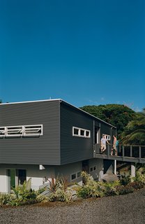 Mike Kurokawa and Paul Fishman set out for the beach from their house in the Puna region of Hawaii. A bridge leads from street level to the upper floor of the house, which is situated in a natural depression, or kipuka.