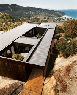 The Kingston house remains unobtrusive and well camouflaged on its hillside site, despite the architects’ use of modernist geometry. The outer cladding is simply plywood that's stained with dark Madison oil.