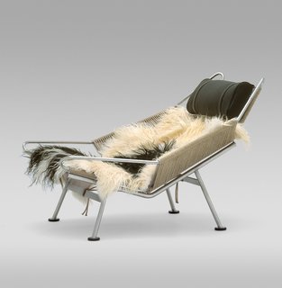 The lush design for the Flag Halyard Chair (1950) was supposedly inspired by a day at the beach, when Wegner was slowing carving himself a spot in the sand to relax. Lounging is supported by 240 meters of flag line strung through a steel frame and sheepskin covering—those coveting this chair can even reserve their own sheepskin. Manufactured by PP Møbler. Photo by Jens Mourits Sørensen.