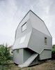 A playful twist on the concept of a pitched roof, the Just K house designed by AMUNT in Tubingen, Germany, features a monochromatic, blue-gray facade with strikingly skewed geometric forms. An exterior staircase leads to a separate entrance at the rear of the building, allowing the structure to be used as two separate units. Photo of These Contemporary Homes Defy Convention modern home