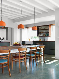 Above the dining room’s Hodgson & Barker Antiques table—found on eBay—are ceramic pendant lights from Hand & Eye Studio. The architect acquired the wood chairs secondhand.