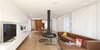 Modern home with Living Room, Hanging Fireplace, Medium Hardwood Floor, and Sofa. One of the biggest parts of the remodel was removing walls on the ground floor to make space for more of an open plan. The hanging steel Gyrofocus Fireplace by Focus gives the living room a unique character. It's flanked by a Delphi sofa from Erik Jørgensen. Photo of A Renovated Modernist Oasis in the French Riviera That Has Hosted Picasso and Royalty