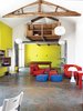 The main living area functions as an easygoing lounge, ideal for entertaining, with a vintage billiards table and low-slung sofas from Ikea. The concrete flooring is durable and easy to clean—a rebuttal to precious French parquet. Photo of Homes Filled with Colorful Furniture modern home