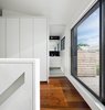Directly at the top of the stairs on the third story, oversized sliding glass doors lead out to a sunny roof deck. To the left, an ensuite bathroom is furnished with Duravit and Wetstyle fixtures. “It has tiny white tumbled marble mosaic tiles, which are very soft underfoot,” Dubbeldam says. Photo 5 of Contrast House modern home