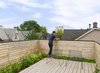 Modern home with Outdoor, Rooftop, Wood Patio, Porch, Deck, Decking Patio, Porch, Deck, Flowers, Gardens, Horizontal Fences, Wall, and Wood Fences, Wall. Two Harry Bertoia-designed chairs sit on the main third story deck, which includes a hidden green roof that absorbs rainwater, cools the upper floors, and purifies the air. “It’s a nice little oasis on the roof, with plants that bloom at different times of year. The owners love spending time up there,” Dubbeldam says. Photo 6 of Contrast House