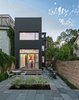 Modern home with Outdoor, Back Yard, Stone Patio, Porch, Deck, Horizontal Fences, Wall, and Wood Fences, Wall. The team carried the concept of contrast through the exterior, juxtaposing the home’s 125-year-old red brick façade with vertical, black-stained cedar cladding at the back. “We wanted to celebrate the old alongside the new,” Dubbeldam says. Since the house is so well insulated, the extra heat that dark exteriors typically draw doesn’t penetrate beyond the boards’ surface. Photo 8 of Contrast House