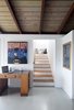 Modern home with Office and Desk. To accommodate a second story, the ground-level had to be completely reconfigured in favor of a more open floor plan. A vintage 1930s Belgian desk acts as a versatile table for the downstairs. Photo 6 of Hillside House No. 3