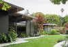 Modern home with House Building Type, Wood Siding Material, Outdoor, Grass, Walkways, and Concrete Patio, Porch, Deck. In the back, ferns and other shade-friendly plants thrive beneath the home’s deep overhangs. Photo of Modern Master: Joseph Eichler
