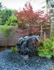A contractor drilled holes in a boulder, creating a fountain that he placed in the backyard outside the master bedroom, where the sound of water lulls the Kreadens to sleep. Photo of Water Features We Love modern home