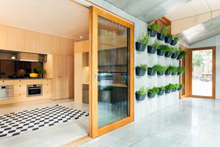 There are two zones in the house. One side, which the architects refer to as the "buffer zone," faces north, capturing the sunlight in the winter and pulling it into the house. In the summer, it traps the harsh sun so less gets into the living space. Edible planters adorn the wall.