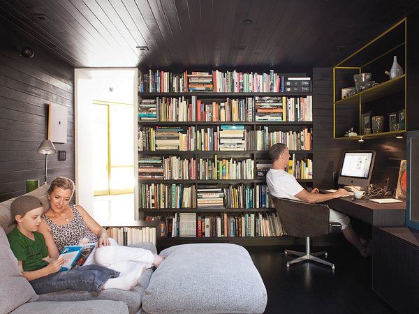 In the den, Lara and Cal read a Hardy Boys mystery on the Flexform Groundpiece sofa by Antonio Citterio while Chris works in his "office." The cozy room where the family spends much of their time once housed the kitchen.