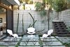 Modern home with Outdoor, Small Patio, Porch, Deck, Concrete Patio, Porch, Deck, Concrete Fences, Wall, Walkways, Hardscapes, Garden, Gardens, Trees, and Back Yard. Outside, a set of Bertoia chairs offer an appealing perch around a vintage glass-and-metal table. Photo of Design Guide: San Diego