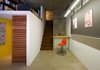 Nestled between an existing concrete wall at right and the new reading loft at left is the entrance staircase, which Colkitt sheathed in rusted steel panels. He used Homasote, invented in 1909 and made from recycled post-consumer paper, for the work board at right and elsewhere in the space. “You can drill on it or tack onto it, and it’s more flexible than drywall,” notes Colkitt. Beneath the new reading loft, which is clad in drywall and set between the wall and the staircase, is a new hallway and dressing area leading to the bathroom. Photo by Cheryl Ramsay. Photo of Design Guide: San Diego modern home