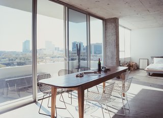 There used to be walls; now Barbara Hill's bed offers views not just of Houston, but also a French farm table surrounded by a sextet of black and white Harry Bertoia chairs for Knoll.