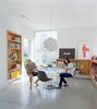 Modern home with Dining Room, Concrete Floor, Shelves, Pendant Lighting, Table, Recessed Lighting, Storage, and Chair. The dining room is meant to be a flexible space for eating or dancing. “One of the most important things for me,” explains Grunbaum, “is how a house feels. It has to be a place where you don’t want to leave.” The Cyclone table is by Isamu Noguchi for Knoll and the pendant lamp is by Lightoiler. Photo of Eames Molded Chairs