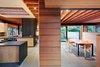 Modern home with Kitchen, Wood Cabinet, and Slate Floor. The first floor consists of two long and narrow structures that intersect in an open kitchen, providing distinct programmatic areas and settling into the tree-lined landscape, allowing yards to surround and permeate each room. Photo 2 of Low/Rise House
