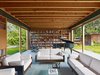 Modern home with Living Room, Chair, Sofa, Slate Floor, Coffee Tables, and Bookcase. Large sliding glass doors suspend the living room within the landscape for family gatherings or larger events. Photo 3 of Low/Rise House