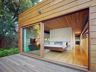 In this sustainable home in Silicon Valley, the primary suite opens to a deck and fern garden with large, sliding glass doors.