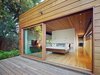 Modern home with Bedroom, Light Hardwood Floor, and Bed. The private master suite opens into a fern garden in the eastern corner of the site. Photo 6 of Low/Rise House