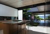 The kitchen, the heart of the house, has a direct view of the adjacent lake. Quartz countertops are paired with lacquered MDF cabinets. Photo of Kitchens with Killer Views modern home