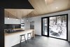 Modern home with Kitchen, Wood Counter, and Slate Floor. In the kitchen, the architects reigned in the house’s high ceilings for a more intimate feel; its lower height also tastefully hides unsightly ducting necessary for ventilation. Beneath the bar sit two Kaysa Black Bar Stools by Baxton Studio. A Gessi faucet complements a Blanco Modex sink. Photo of Kitchens with Killer Views