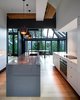 Modern home with Kitchen, Pendant Lighting, White Cabinet, and Light Hardwood Floor. The residents collaborated with the architects to achieve the sharp graphic sensibility they desired. Part way through the project, they realized the space would be more compelling in muted tones. Photo of Kitchens with Killer Views