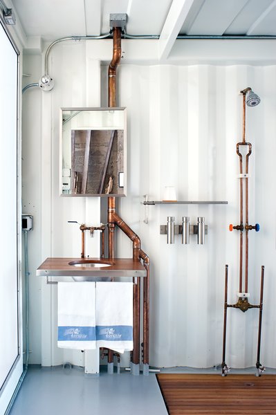 Though we love the custom teak-and-steel sink, shelving, shower caddy, mirror, shower, and vanity by Pat Carson Studio, the real coup of this bathroom is that the window at left goes from transparent to opaque with the touch of a button. The Duo Poliert dispensers beneath the shelf are from Blomus. A toilet opposite the sink is from Toto.