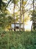 Modern home with Exterior, Flat RoofLine, Cabin Building Type, and Prefab Building Type. The Fish Camp acts as the couple’s forest getaway, just a quarter mile from their main house. Photo of Simple American Getaways
