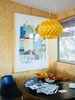 Modern home with Dining Room, Pendant Lighting, Table, and Chair. Natural wooden walls clad the dining room corner, while a marigold lantern hangs above. Photo of How To: Decorating with Posters