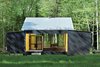 Modern home with Exterior, Prefab Building Type, House Building Type, Cabin Building Type, Metal Roof Material, Wood Siding Material, and Glass Siding Material. Architect Charlie Lazor opted for a wash of black on the prefab cabin he designed on Madeline Island, Wisconsin. Photo of Superior Logic