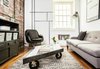 Modern home with Living Room, Sofa, Coffee Tables, Medium Hardwood Floor, Chair, Floor Lighting, Storage, and Rug Floor. A parallelogram-shaped window pane, rescued from an architectural salvage yard, was outfitted with steel edges and casters, and repurposed as a coffee table. Photo by Alan Gastelum. Photo of Modern Homes That Are 500 Square Feet or Less
