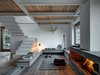 Modern home with Living Room, Medium Hardwood Floor, Wood Burning Fireplace, Lamps, Bench, and Wall Lighting. “The inside is, for the most part, concentrated on the local craftsmanship, because I believe it is very important,” Vanotti says. “It represents our history.” Artisan Vanotti Mauro built many parts of the building, including its most prominent feature: the larch wood accents. A custom fireplace warms the living room. Photo of A Stunning Alpine Home with Sweeping Views and Custom Crafted Interior