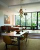The dining room and the living room open up into the garden. The architects engineered a steel support that allowed the rear wall to be blown out and replaced it with a window that floods the room with light and gives a panoramic view of the garden. Photo by Tara Donne. Photo of Modern Brooklyn Row House Renovation modern home