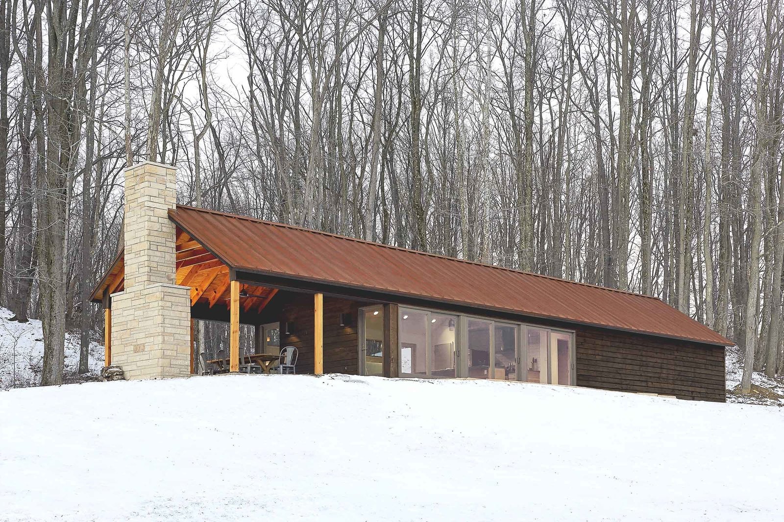 The retreat’s southern exposure maximizes sunlight with 24 feet of floor-to-ceiling windows. The sun’s warmth is absorbed and stored in the concrete floor, keeping the interior warm. Combined with thickly insulated walls, the cabin requires little additional energy, and has gone up to three days in winter without any electrical heating.