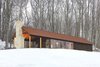 The retreat’s southern exposure maximizes sunlight with 24 feet of floor-to-ceiling windows. The sun’s warmth is absorbed and stored in the concrete floor, keeping the interior warm. Combined with thickly insulated walls, the cabin requires little additional energy, and has gone up to three days in winter without any electrical heating. Photo 3 of Off-Grid Retreat modern home