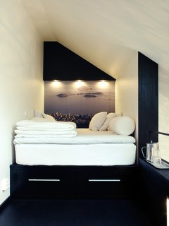 In this tiny sleeping loft is a platform bed with two drawers beneath it. In place of wallpaper, Schönning enlarged a photograph he snapped in Rio de Janeiro. The inset spotlights and a small shelf at the end of the bed offer light and additional storage. 