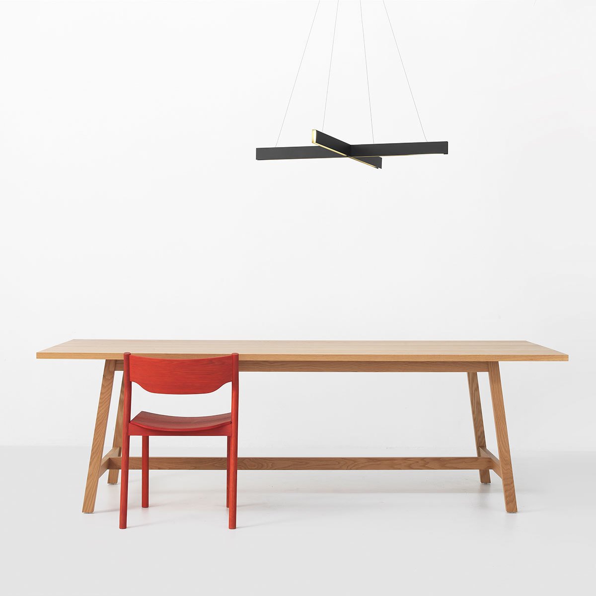 The Cross Pendant is comprised of two intersecting aluminum channels that diffuse warm lighting through recessed LEDs. Powder-coated in a matte black or white, the pendant can be used over a dining room table or as overhead lighting in a living room or bedroom.